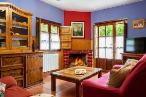 ein Wohnzimmer mit Kamin und einem Tisch in der Unterkunft Socastillo C in Fresnedo