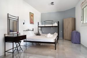 a bedroom with a bed with a piano and a desk at Iguana studio 12 in Preveza