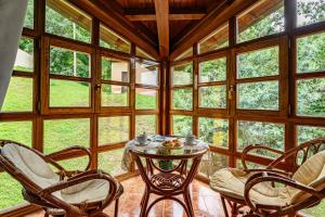 ein Wintergarten mit Tisch und Stühlen in einem Raum mit Fenstern in der Unterkunft Socastillo C in Fresnedo