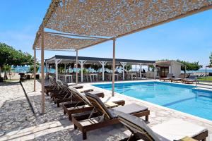 a pool with chaise lounge chairs and a swimming pool at Iguana studio 12 in Preveza