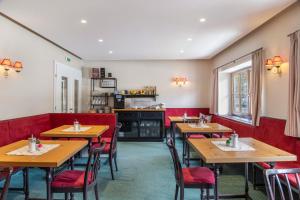 a restaurant with wooden tables and red chairs at Chalet Sonneck - Seefeld in Seefeld in Tirol