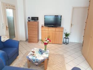 a living room with a blue couch and a tv at Ferienwohnung Strandperle-Schilksee in Schilksee