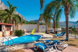a swimming pool with two chairs and a slide at Villa Ina in Cinisi