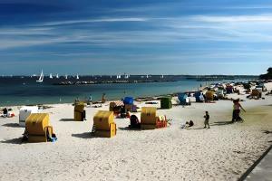 a beach with a bunch of chairs and people on it at Ferienwohnung Strandperle-Schilksee in Schilksee