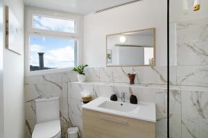 a white bathroom with a sink and a mirror at Carmelo y Carmela 6 in Teror +21 photos