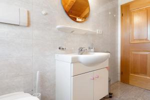a white bathroom with a sink and a toilet at Mayr Apartments Fünf in Plaus