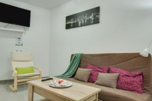 a living room with a brown couch with pink pillows at 1b Srv in Vecindario