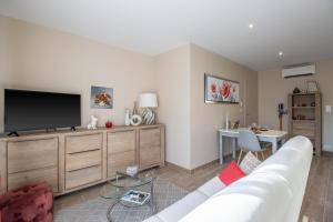 a living room with a couch and a flat screen tv at Gite le Pic Epeiche in Sarlat-la-Canéda