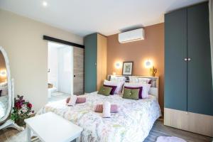 a bedroom with a large bed with pink and green pillows at Gite le Pic Epeiche in Sarlat-la-Canéda
