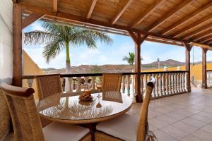 a patio with a table and chairs on a balcony at Villa Christisay in San Bartolomé
