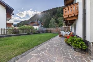 a backyard with a stone walkway and a lawn at Ferienwohnung Ainhauser in Campolasta