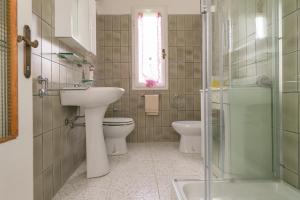 a bathroom with a sink and a toilet and a window at Appartamento Stella in Chianni