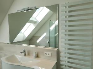 a bathroom with a sink and a mirror at Ferienwohnung Munzert - Bodensee in Langenargen +28 photos