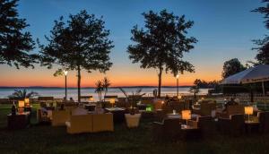 a group of people sitting in chairs watching the sunset at Ferienwohnung Munzert - Bodensee in Langenargen
