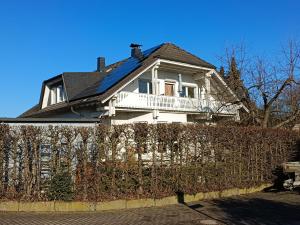 a white house with a fence in front of it at Ferienwohnung am Wald in Eppenrod