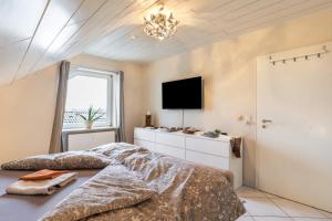 a bedroom with a bed and a tv and a window at Ferienwohnung am Wald in Eppenrod