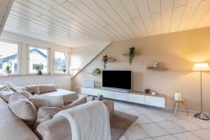 a living room with a couch and a tv at Ferienwohnung am Wald in Eppenrod