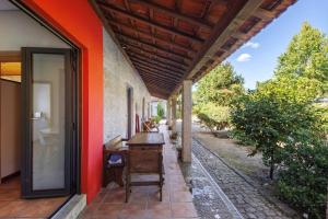 an outside porch of a house with a wooden table at Casa de Andrães Magnolias in Marco de Canaveses