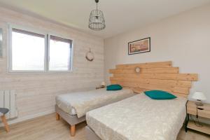 a bedroom with two beds and a desk at Gîte Le Champ Du Bois in Missillac