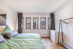 a bedroom with a bed and a desk and windows at Werner-Senger-Haus Limburg in Limburg an der Lahn