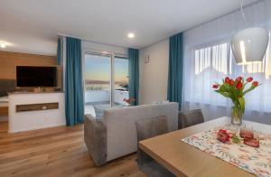 a living room with a dining table and a television at Appartements Bank Am See in Immenstaad am Bodensee