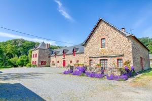 a stone building with purple flowers in front of it at Gîte Le Champ Du Bois in Missillac
