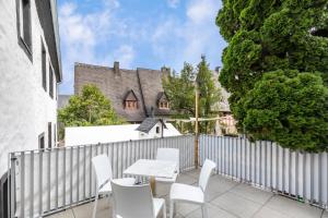 a patio with white chairs and a table and a fence at Werner-Senger-Haus Limburg in Limburg an der Lahn