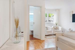 a white living room with a vase in a room at Privatzimmer Kippenhausen in Immenstaad am Bodensee