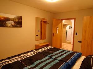 a bedroom with a bed and a mirror on the wall at Ferienwohnung Mühlengrün in Oberwolfach