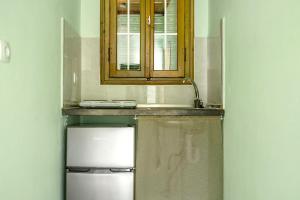 a kitchen with a sink and a refrigerator at Old Boat apartment in Nikiana