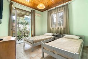 a bedroom with two beds and a balcony at Old Boat apartment in Nikiana