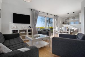 a living room with two couches and a tv at Meerzeit in Mellnitz
