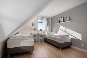 a attic bedroom with two beds and a window at Meerzeit in Mellnitz