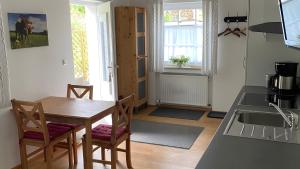a kitchen with a table and chairs and a sink at Pfoten und Berge Oberreute in Oberreute