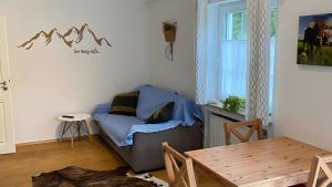 a living room with a couch and a table at Pfoten und Berge Oberreute in Oberreute
