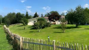 a fence in front of a house with a yard at Pfoten und Berge Oberreute in Oberreute