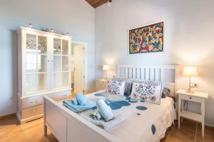 a bedroom with a large bed with blue pillows at Vivero El Suso in La Manga del Mar Menor