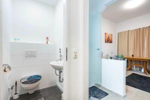 a bathroom with a toilet and a sink at Aldars Urban Trio Suite Nr. 9 in Munich +15 photos