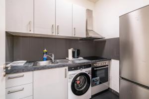a kitchen with a washing machine and a sink at Aldars Urban Trio Suite Nr. 9 in Munich
