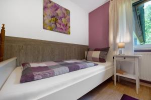 a bedroom with a bed and a window at Fewo Birkenallee - Lavendel in Deinste