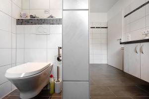 a white bathroom with a toilet and a sink at Fewo Birkenallee - Lavendel in Deinste +16 photos