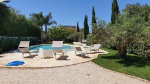 a group of chairs and a table next to a pool at Villa Dammusello in Marsala