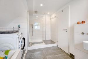 a bathroom with a washing machine and a shower at Ferienwohnung Feuerbach in Telgte +29 photos