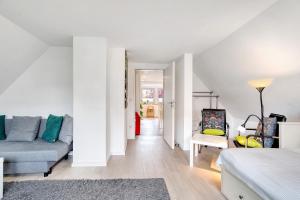 a white living room with a couch and a chair at Ferienwohnung Feuerbach in Telgte