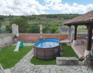 a small backyard with a pool and a playground at El Pico Llanillo in San Miguel del Arroyo