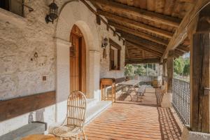 an outdoor porch with a chair and a table at El Pico Llanillo in San Miguel del Arroyo
