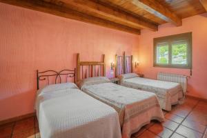 three beds in a room with pink walls at El Pico Llanillo in San Miguel del Arroyo +28 photos