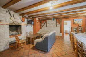 a living room with a stone fireplace and a table at El Pico Llanillo in San Miguel del Arroyo