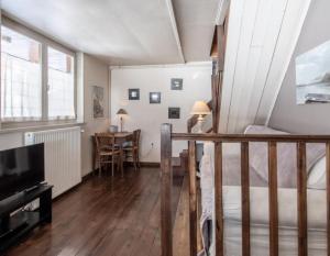 a living room with a table and a television at Chalet Arclosan - Saint-Ferréol in Saint-Ferréol