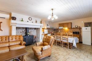 a living room with a fireplace and a table and chairs at Le haut Picot in Bussac